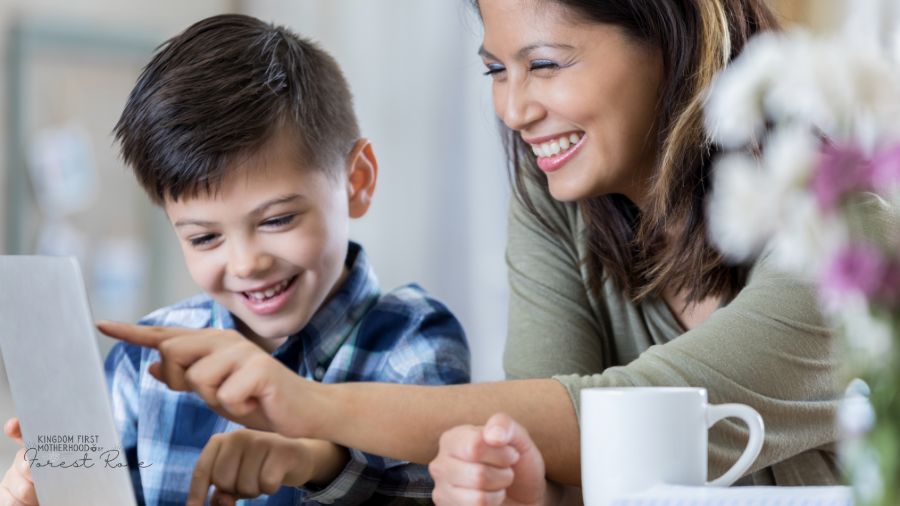 homeschooling mom helping son on laptop with school work