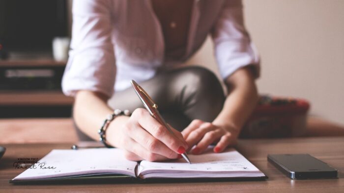 woman writing in a planner how to plan a homeschool schedule