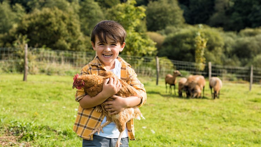 happy little boy holding a chicken