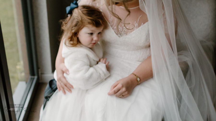 Women in wedding dress holding little girl - Fashion Pieces Mothers Pass on to their daughters