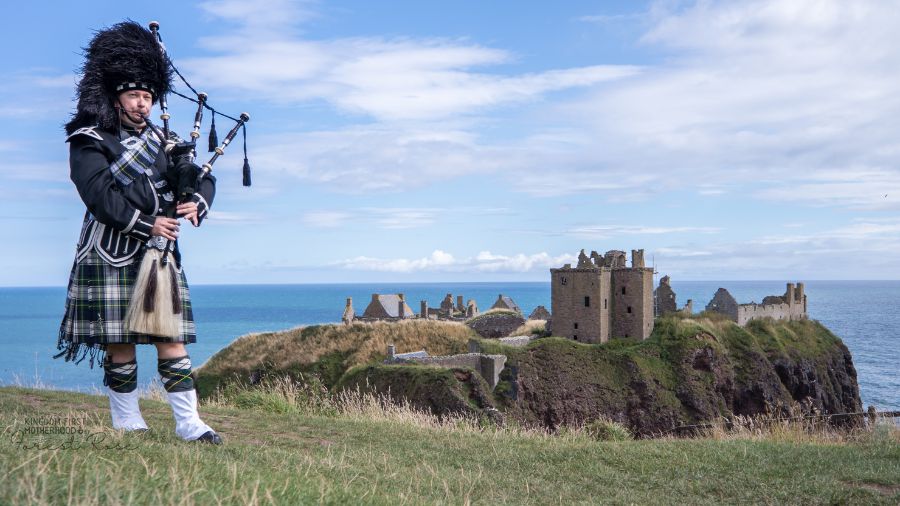 traditional bagpiper in Scotland at Dunnottar Castle